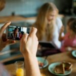 A person taking a picture of someone at the table
