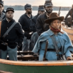 A group of men standing around in boats.