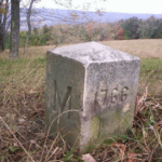A stone marker in the middle of a field.