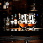 Two glasses of whiskey on a bar