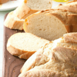 A wooden cutting board with bread on it.
