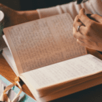 A person is reading a book on the table