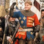 A man in medieval garb holding a sword.