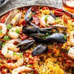 A plate of food with shrimp, mussels and rice.