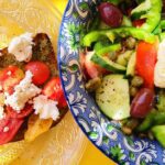 A salad and sandwich are on the table.