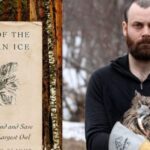 A man holding an owl in his arms.
