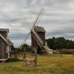 A windmill that is leaning on the side of a building.