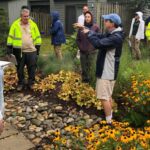 A group of people standing around in the yard.