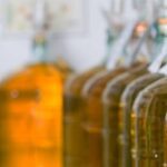 A row of bottles with different flavors of wine.