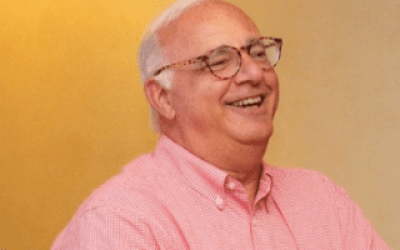 A man with glasses and a pink shirt