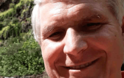 A man with white hair smiling for the camera.