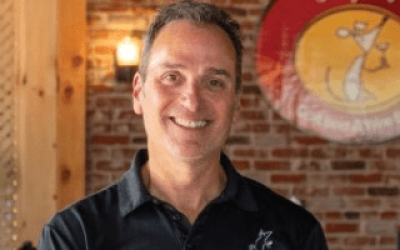 A man in black shirt smiling for the camera.