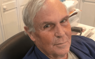 A man with white hair and wearing glasses.